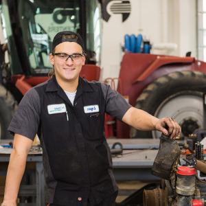 一名学生在穆尔黑德柴油设备技术实验室的拖拉机前摆姿势